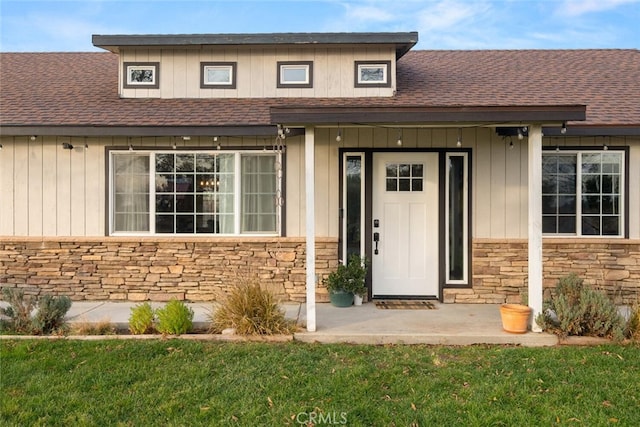 view of exterior entry featuring a lawn