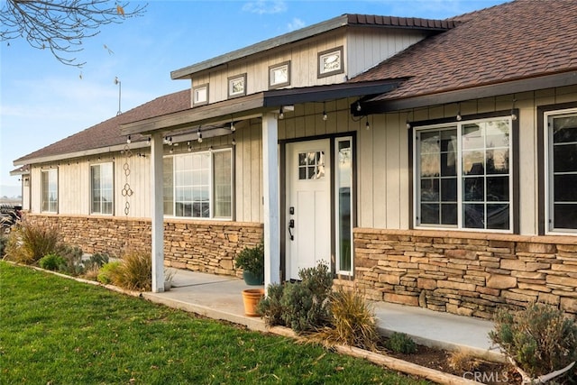 view of exterior entry with a lawn