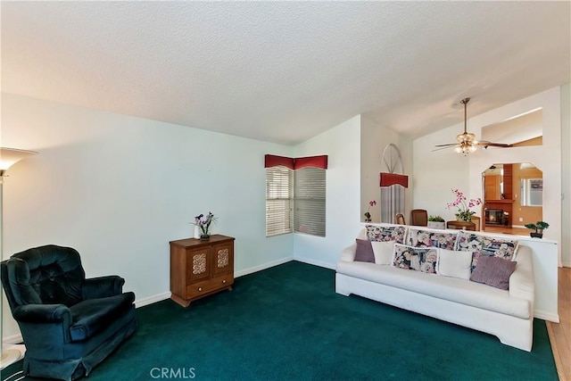 sitting room with lofted ceiling, ceiling fan, baseboards, and a textured ceiling