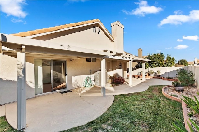 back of property with stucco siding, a lawn, a patio area, fence, and a pergola