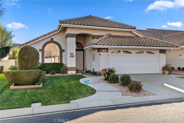 mediterranean / spanish-style house featuring stucco siding, an attached garage, a front yard, driveway, and a tiled roof