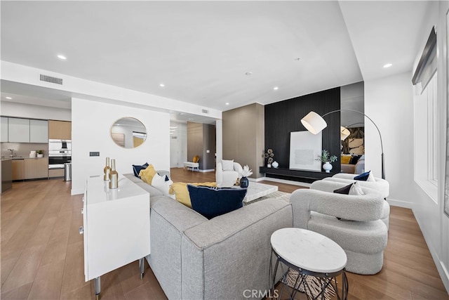 living room featuring light hardwood / wood-style floors and sink