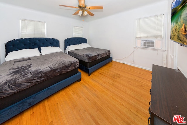 bedroom featuring ceiling fan, cooling unit, and wood-type flooring