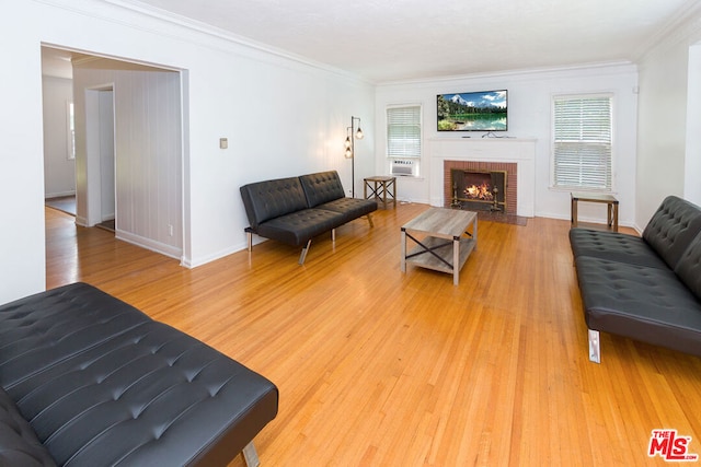 living room featuring crown molding, wood-type flooring, and a brick fireplace