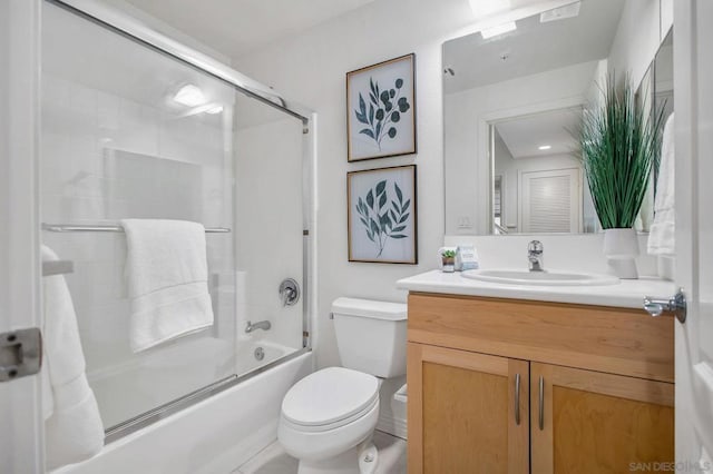 full bathroom with combined bath / shower with glass door, vanity, and toilet