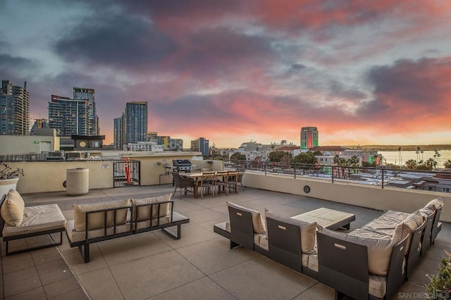 patio terrace at dusk with a water view and an outdoor hangout area