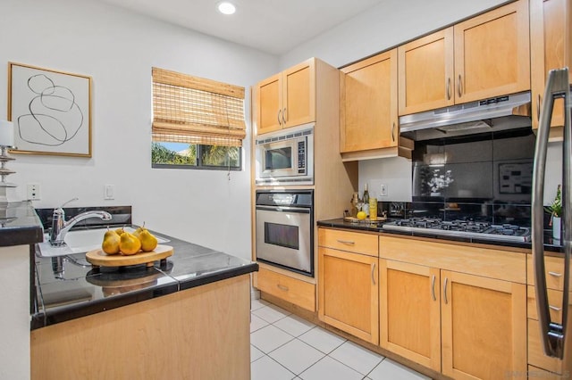 kitchen featuring light tile patterned floors, appliances with stainless steel finishes, light brown cabinets, and sink