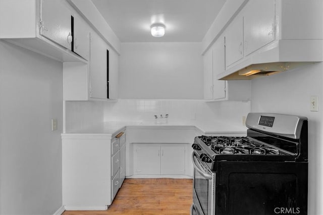 kitchen with white cabinetry, sink, stainless steel gas range oven, light hardwood / wood-style flooring, and decorative backsplash