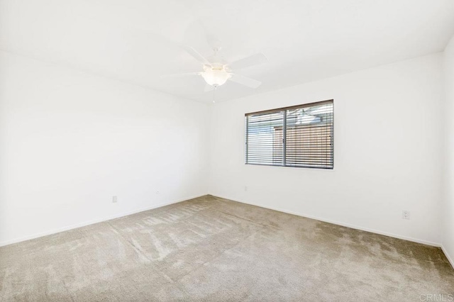 empty room featuring ceiling fan and light colored carpet