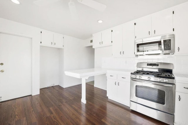 kitchen with decorative backsplash, dark hardwood / wood-style flooring, white cabinetry, and appliances with stainless steel finishes