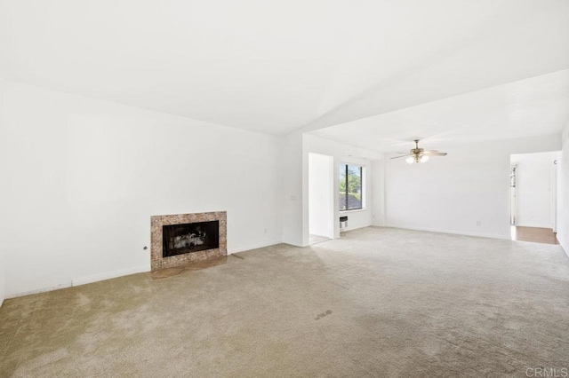 unfurnished living room with ceiling fan, lofted ceiling, light carpet, and a high end fireplace