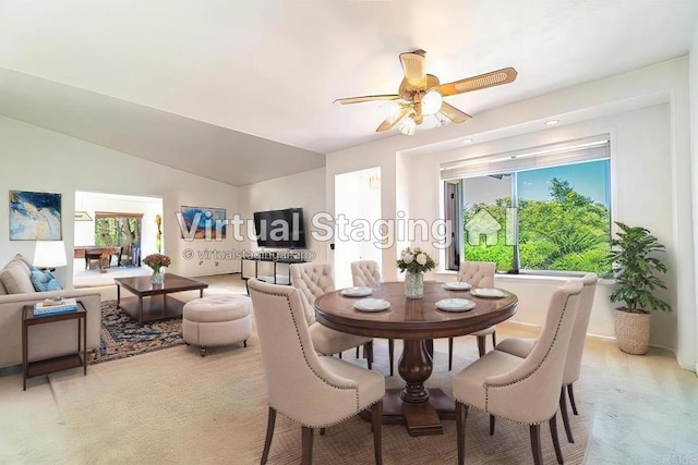 carpeted dining area with ceiling fan and vaulted ceiling