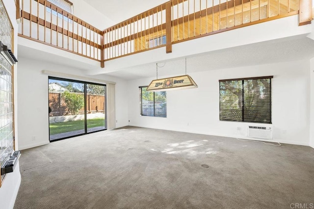 unfurnished living room featuring carpet flooring and a high ceiling