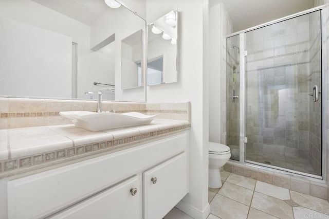 bathroom featuring walk in shower, tile patterned flooring, vanity, and toilet