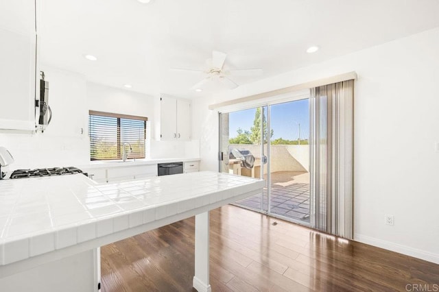 kitchen featuring tile countertops, plenty of natural light, and white cabinets