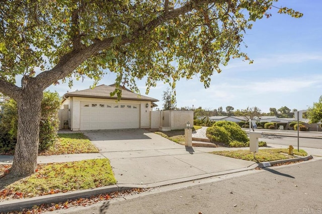 view of front of home with stucco siding, driveway, and a garage