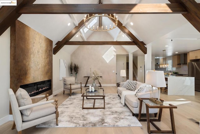 living room with beamed ceiling, a fireplace, light hardwood / wood-style floors, a chandelier, and high vaulted ceiling