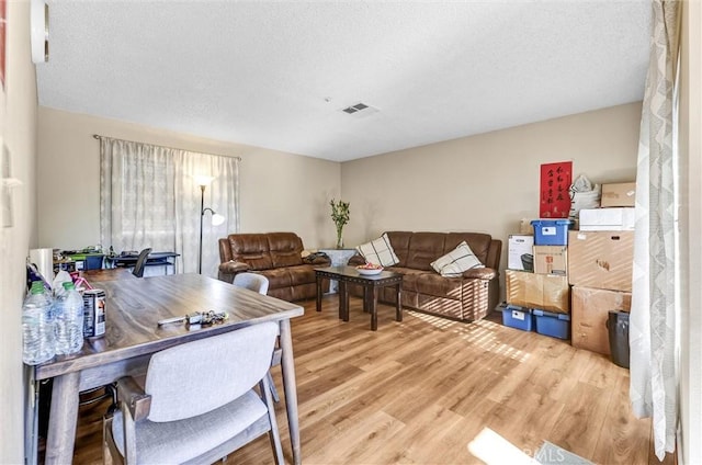 interior space with a textured ceiling and light hardwood / wood-style floors