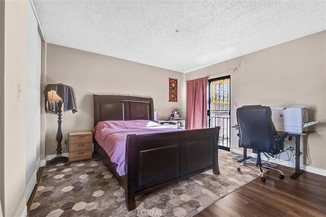 bedroom featuring dark hardwood / wood-style flooring and a textured ceiling