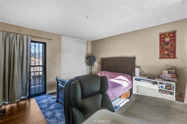 bedroom with wood-type flooring and a textured ceiling