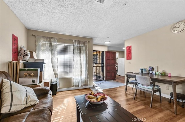 living room with light hardwood / wood-style floors and a textured ceiling