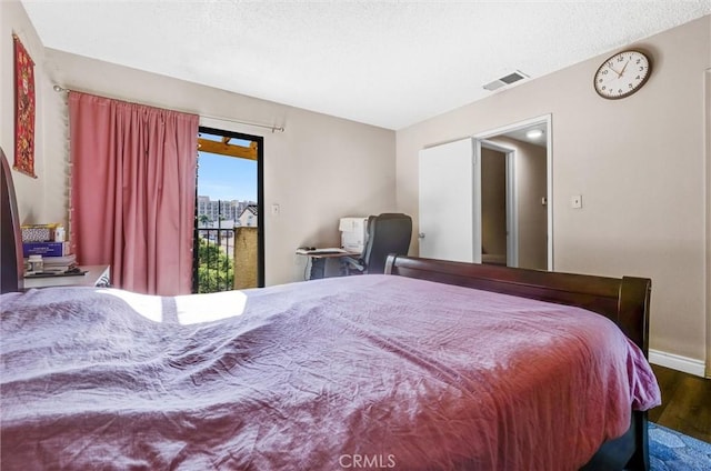 bedroom with access to outside and hardwood / wood-style flooring