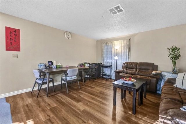 living room with a textured ceiling and hardwood / wood-style flooring