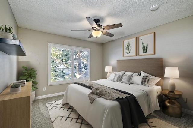 bedroom featuring light carpet, ceiling fan, and a textured ceiling