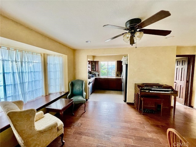 sitting room with ceiling fan and light hardwood / wood-style flooring