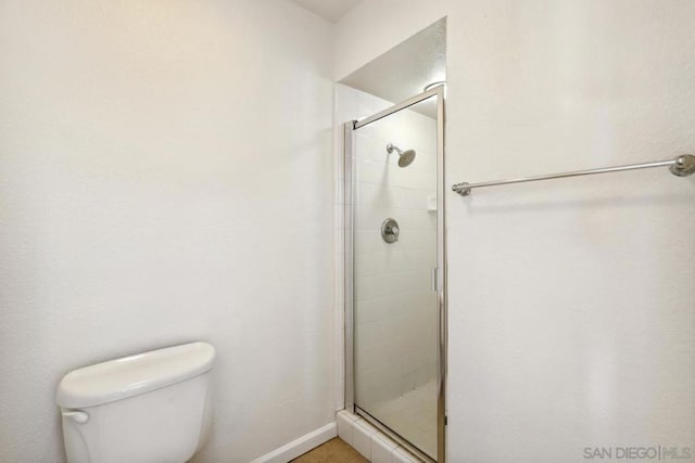 bathroom with toilet and a shower with shower door