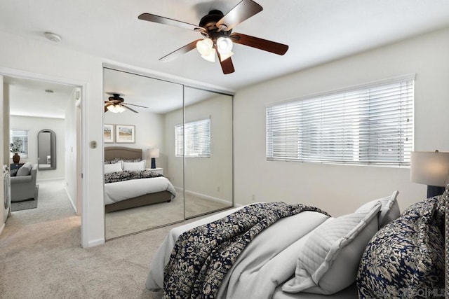 bedroom featuring ceiling fan, a closet, and light carpet