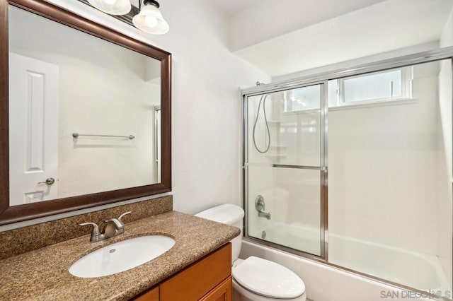 full bathroom featuring vanity, toilet, and enclosed tub / shower combo