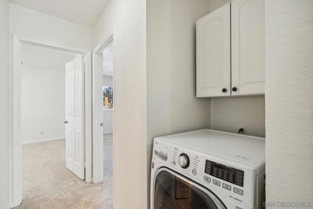 laundry room with light carpet, washer / dryer, and cabinets