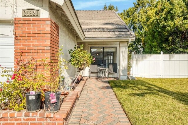 entrance to property featuring a lawn