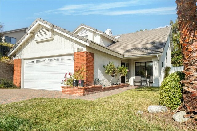 single story home featuring a garage and a front yard