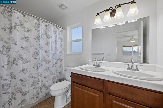 bathroom featuring a shower with shower curtain, vanity, ceiling fan, tile patterned flooring, and toilet