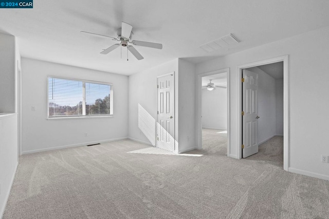 spare room with ceiling fan and light carpet