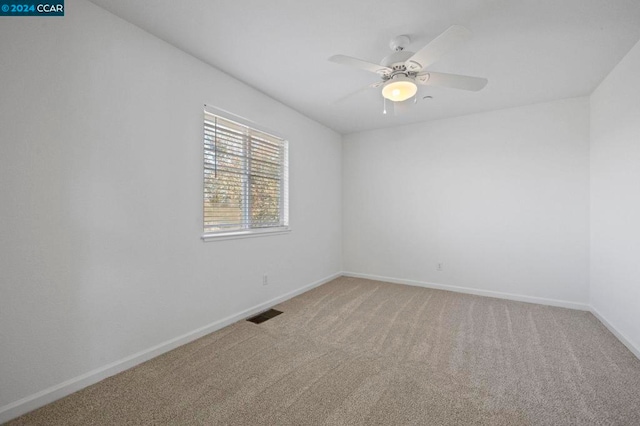 carpeted spare room with ceiling fan