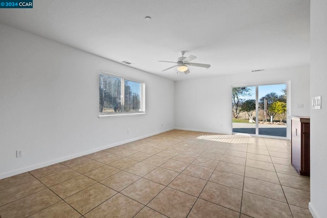 empty room with ceiling fan and light tile patterned floors