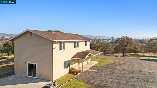 view of side of property featuring a mountain view and a patio