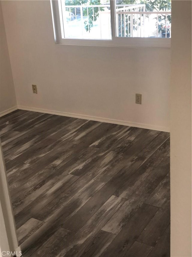 empty room with dark hardwood / wood-style flooring