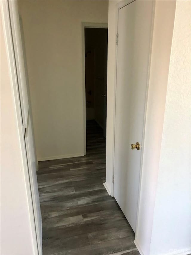 corridor with dark hardwood / wood-style flooring