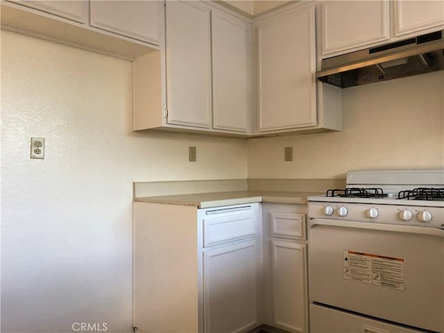 kitchen with white range oven, white cabinetry, and extractor fan