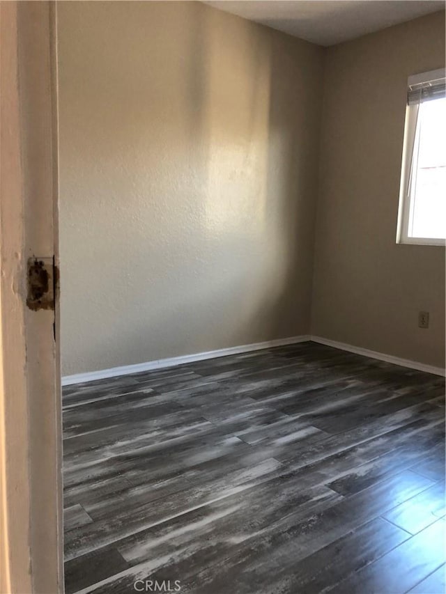 spare room with dark wood-type flooring