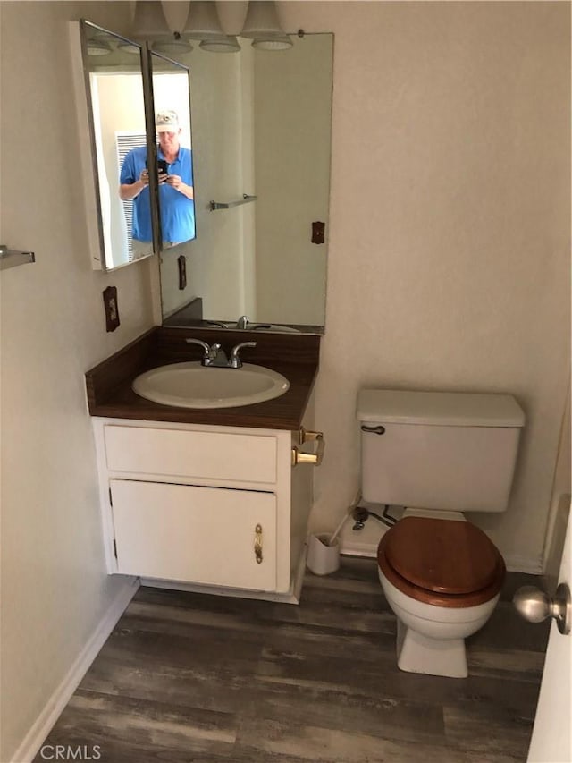 bathroom featuring vanity, hardwood / wood-style flooring, and toilet