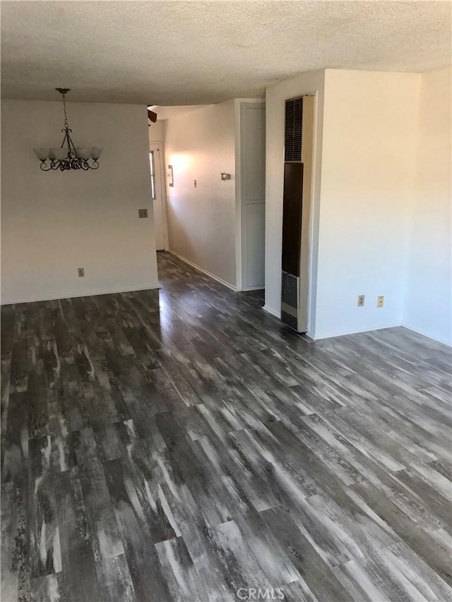 unfurnished room featuring a textured ceiling and dark hardwood / wood-style floors