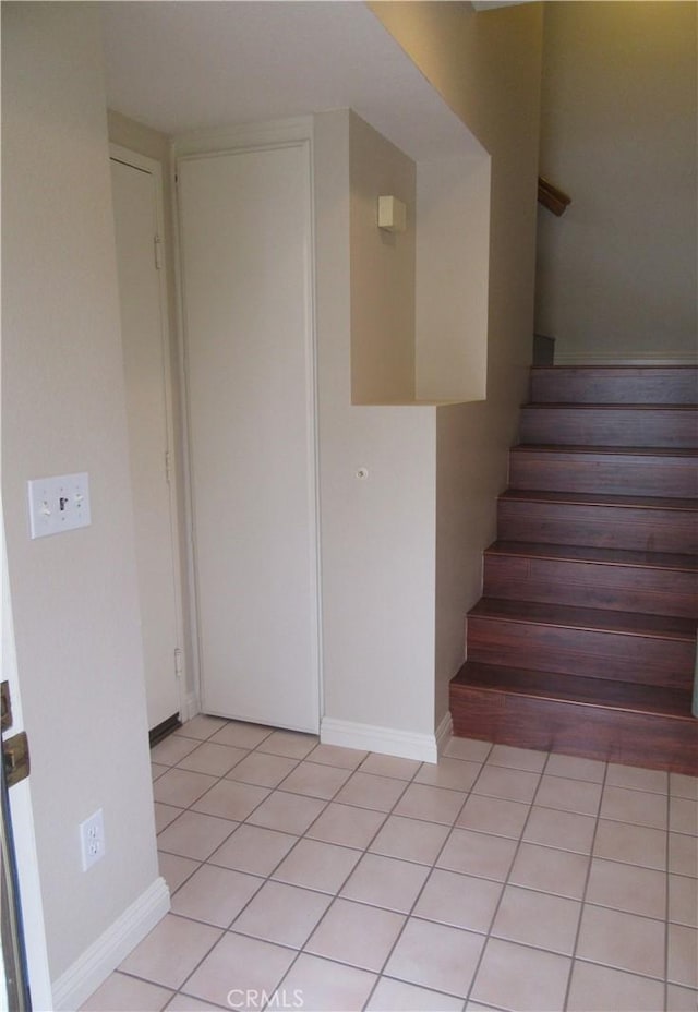 stairway featuring tile patterned flooring