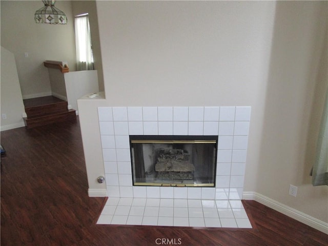 interior details featuring a tile fireplace and wood-type flooring