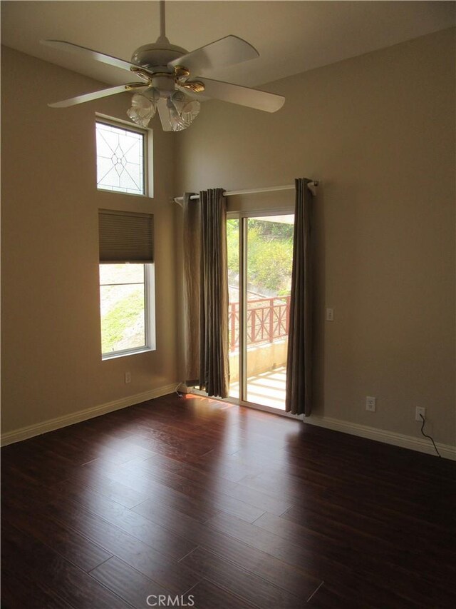 empty room with a wealth of natural light, ceiling fan, and dark hardwood / wood-style floors