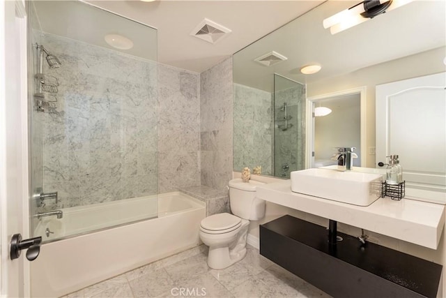 full bathroom featuring toilet, sink, and tiled shower / bath